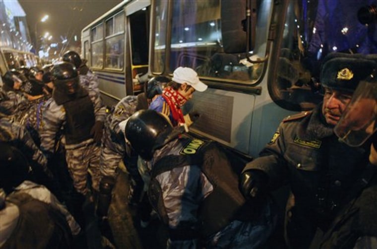 Police detain a protester wearing a Spartak Moscow club scarf outside the Kievsky train station in Moscow on Wednesday.